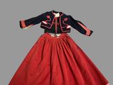 une robe rouge et bleue, avec une veste noire et une jupe rouge