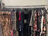 a lot of clothes hanging on a rack in a room