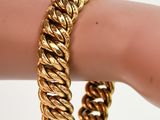 un gros plan sur la main d'une personne portant un bracelet en or