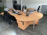 a desk with a computer and a chair in a room