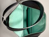 a black and green purse hanging on a wall