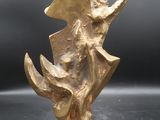 sculpture en bronze représentant un poisson, posée sur un socle en marbre, sur fond noir