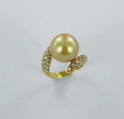 une bague en or sertie d'une perle et de diamants, sur fond blanc