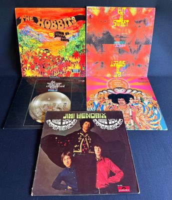 trois albums vinyles des Beatles, dont l'un comporte la photo d'un homme coiffé d'un chapeau et d'une femme en robe rouge