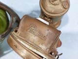a close up of a small metal object with a green object in the background