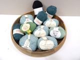 many balls of yarn in a wooden bowl on a table