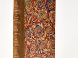 an old book that is sitting on a white surface