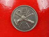 a red fire hydrant with a silver coin on it