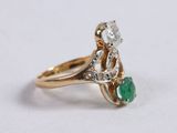 a close up of a gold ring with a green and white stone