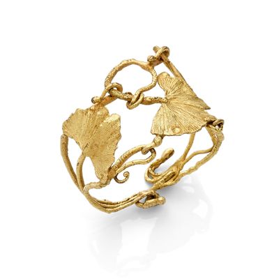 a close up of a gold ring with leaves on it