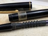 three pens sitting next to each other on a table