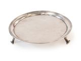 a silver plate on a stand on a white surface