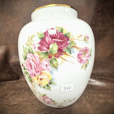a white vase with pink and yellow flowers painted on it