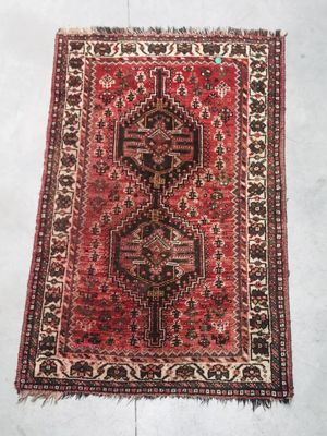 a red and black rug on a white floor
