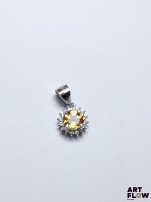 un gros plan d'un pendentif en diamants jaunes et blancs sur fond blanc