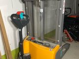 a fork lift truck in a garage next to a pile of wood