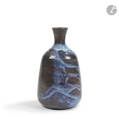 un vase bleu posé sur une surface blanche