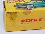 a box of dinky toys with a green car in it