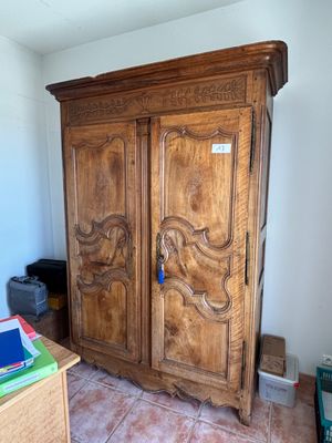 une armoire en bois dans un coin d'une pièce au sol carrelé