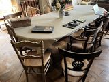 une longue table avec des chaises et un livre posé dessus