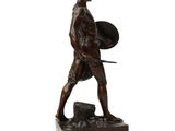 bronze statue of a man with a shield and shield on a wooden base