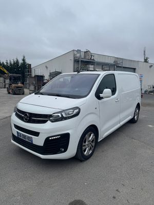 the white van is parked in a parking lot near a building