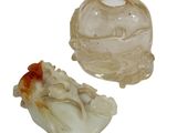 two pieces of carved glass on a white surface
