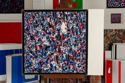 a picture of a painting on a easel in front of a bunch of boxes