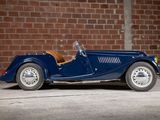 a blue car that is parked in front of a brick wall
