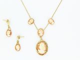 une image représentant un ensemble composé d'un collier et de boucles d'oreilles, sur laquelle figure le portrait d'une femme