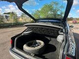 a car with its trunk open and a tire in the trunk
