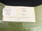a green vase with a tag on it sitting on a table