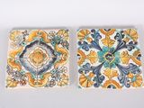pair of tiles with floral designs on them on a white surface