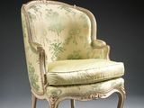 an old fashioned chair with a green and white upholstered seat