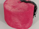 a pink hat that is sitting on a white surface