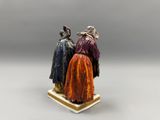 two figurines of three people dressed in medieval clothing