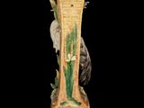 a tall vase with a bird on top of it