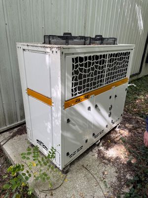 a man standing next to an air conditioner outside