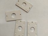 four pieces of white plastic are sitting on a white surface