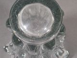 a glass candle holder with a glass base on a table