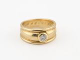 gros plan d'une bague en or avec un diamant au centre