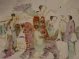 a plate with a painting of a group of people on it