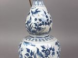 an antique blue and white vase with a handle on top of it