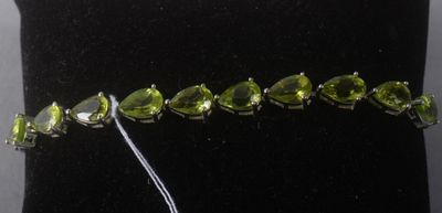 un gros plan sur un bracelet orné d'un bouquet de pierres vertes