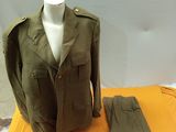 un mannequin vêtu d'une veste et d'un pantalon, posé sur une table