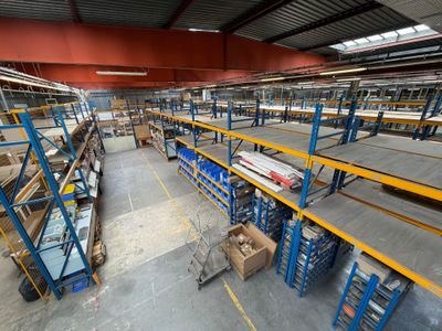 un grand entrepôt rempli d'étagères et de palettes