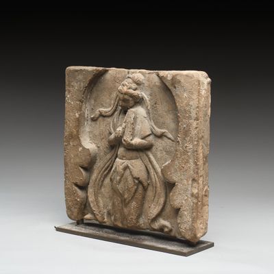an image of a stone relief of a woman holding a flower