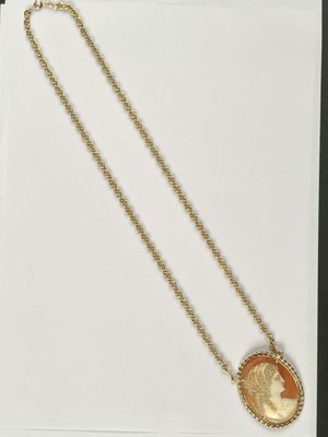 a gold necklace with an image of a woman on it