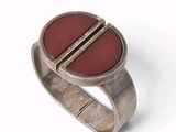 bague en argent massif avec une pierre rouge au centre et un anneau arrondi