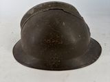 an old helmet sitting on top of a table next to a white wall